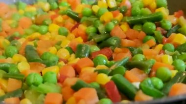 Sebze yemeği. Sebze yahnisini tavada pişir. Salatada dondurulmuş sebzeler. Yarı pişmiş yemek..