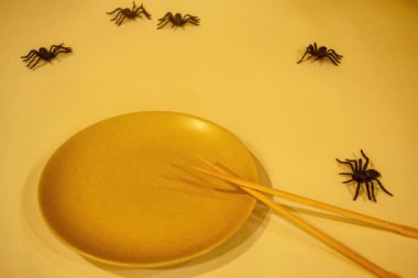 Cadılar Bayramı sofrası. Beyaz arka planda siyah örümcekli bir tabak. Düz konum, üst görünüm moda tatil konsepti. Mozaiği durdurma tarzında animasyon.