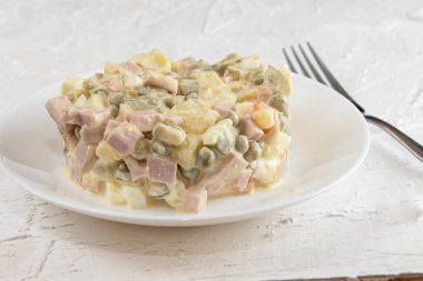 Beyaz arka planda Olivier salatası, nomemade tarifi. Olivier sebze salatası ve cam bir kâse ev yemeği, yakın plan fotoğraf..