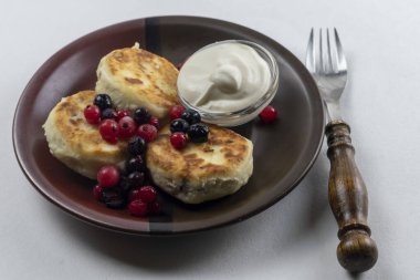 Syrniki ya da süzme peynir ve üzümlü şurup. Sağlıklı kahvaltı konsepti. Lezzetli tatlı veya tatlı kahvaltı.