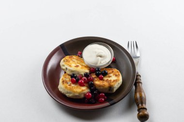 Syrniki ya da süzme peynir ve üzümlü şurup. Sağlıklı kahvaltı konsepti. Lezzetli tatlı veya tatlı kahvaltı.