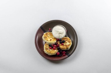 Syrniki ya da süzme peynir ve üzümlü şurup. Sağlıklı kahvaltı konsepti. Lezzetli tatlı veya tatlı kahvaltı.