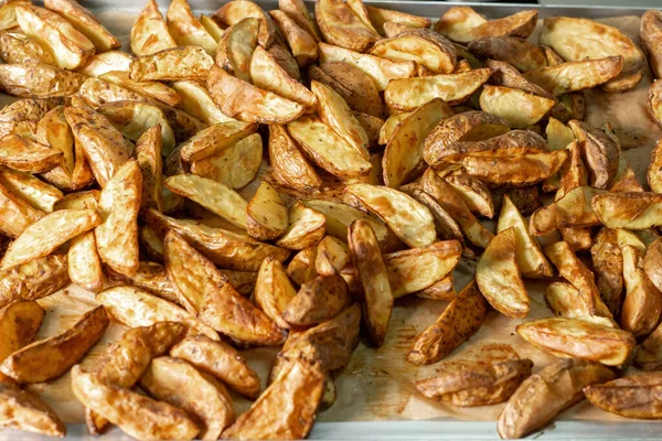 Selective focus. Baking tray with baked potatoes, fragrant rustic potatoes. — Stockfoto