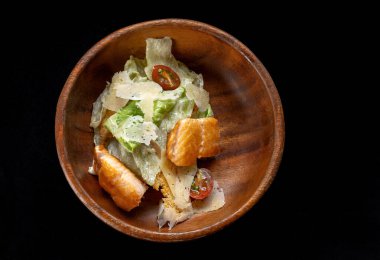 Izgara somonlu Sezar Salatası ahşap tabakta izole edilmiş. Kırmızı balık fileto salatası, mini baget kraker..