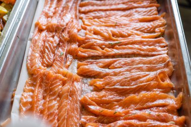 Tuzlanmış ve dilimlenmiş pembe taze somon, fırın tepsisine serilmiş..