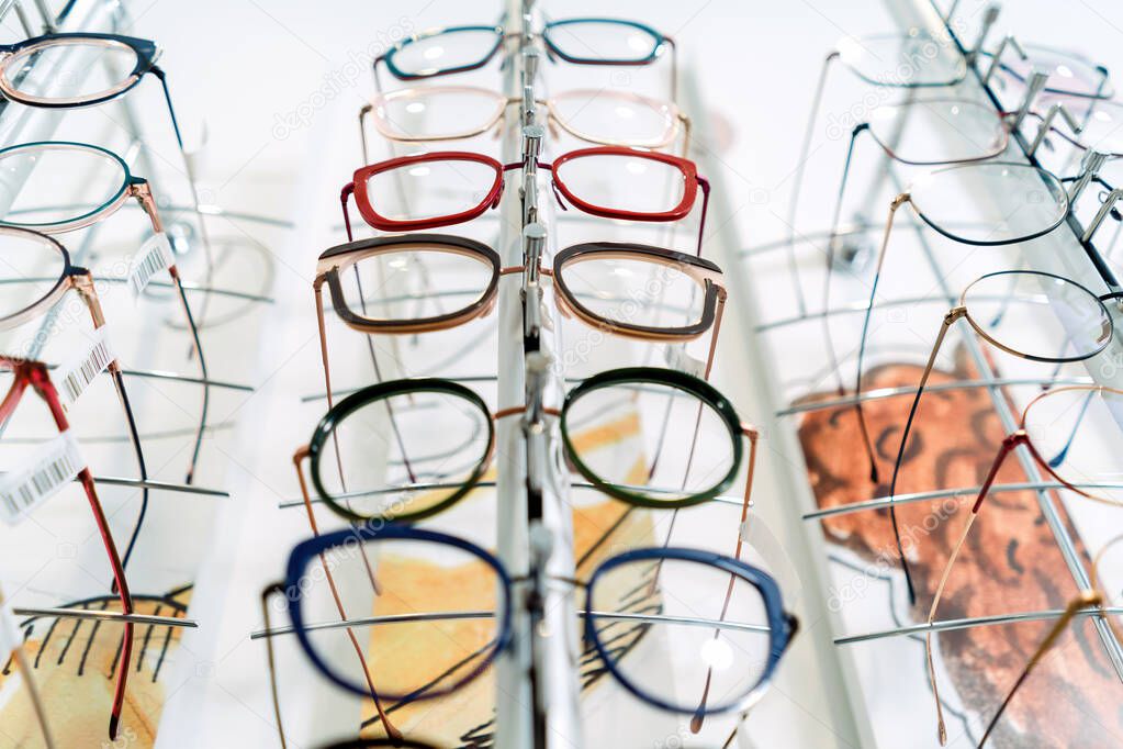 Row of glasses at an opticians, eyeglasses shop. Stand with glasses in the store of optics.