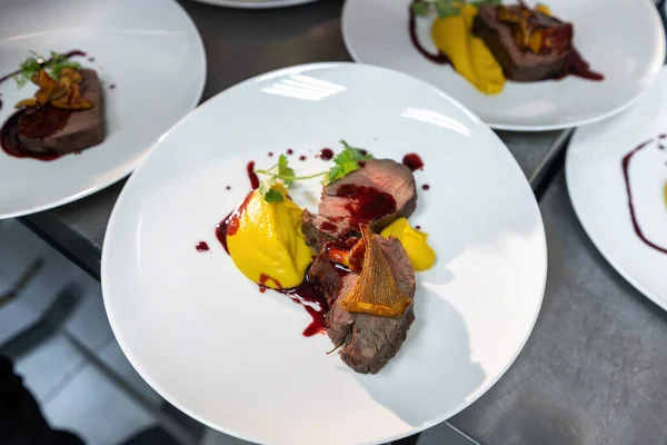 Biftek, şarap sosunda karamelize edilmiş beyaz tabakta chanterelles..