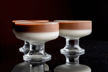 Siyah arka planda cam bardakta jöle. Vazolar siyah cam arka planda yansıtılır.