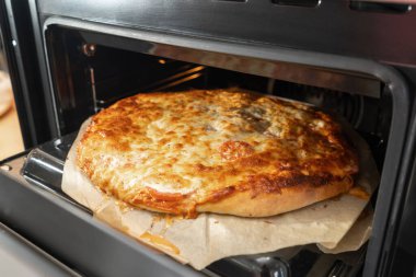 Pizza soslu Pepperoni pizza, mozzarella peyniri ve pepperoni. Fırındaki fırın tepsisindeki pizza..