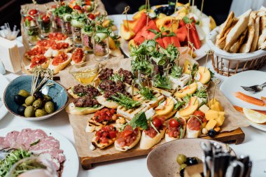 Bir set sulu biftek, peynir tabağı, sağlıklı sebze tabağı, et, sandviç, meyve, carpaccio ve tartar. Sağlıklı yemek.