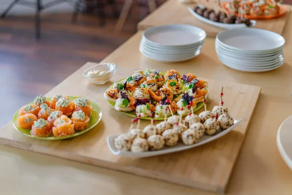 Canapes with cheese balls topped with sesame seeds. Shrimps and profiteroles with pate. — Stock Photo, Image