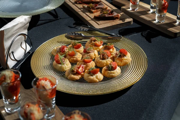 Una delizia per un buffet o una festa in casa. Profiteroles a base di pasta pasticcera con patè. Il tavolo è riservato alla ristorazione. — Foto Stock