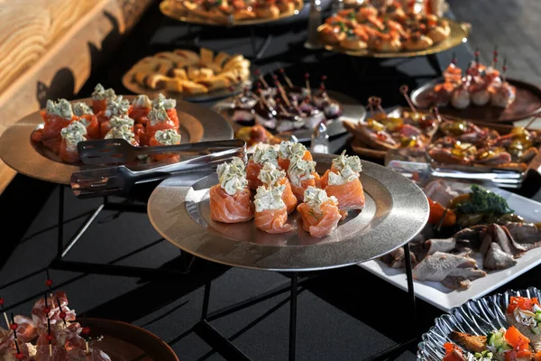 Dereotlu peynirle doldurulmuş somon ruloları. Gümüşi bir yemek, lüks bir yemek servisi, zengin bir masa..