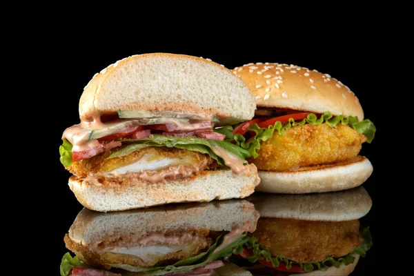 Burger mit Hühnerschnitzel, Salat und Mayonnaise. Auf einem schwarz verspiegelten Hintergrund. — Stockfoto