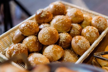 Ev yapımı susamlı hamburger çörekleri, hasır sepetin içinde..