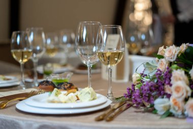 Şık ve zarif, altın kaplama çatal bıçak takımı ve beyaz tabaklar..