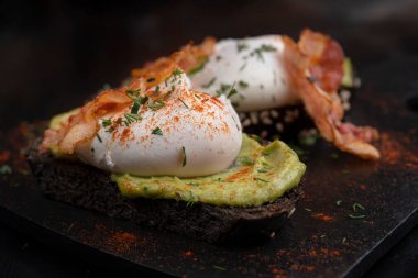 Pastırmalı yumurta ve tost. Siyah tahta üzerine serilmiş..