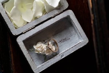 Elmaslı nişan yüzüğü, beyaz bir polimer gülün üzerinde. Güzel ahşap bir kutuda.