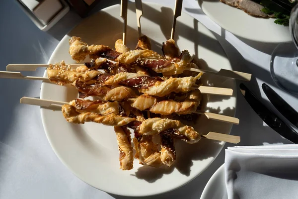 Tocino al horno con masa en pinchos de madera. Retroiluminación, una copa vacía de vino-2. —  Fotos de Stock