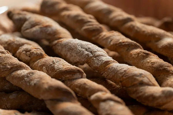 Bastoncini di segale croccanti cosparsi di farina. Rustico, steso su un piatto coperto da un panno. — Foto Stock