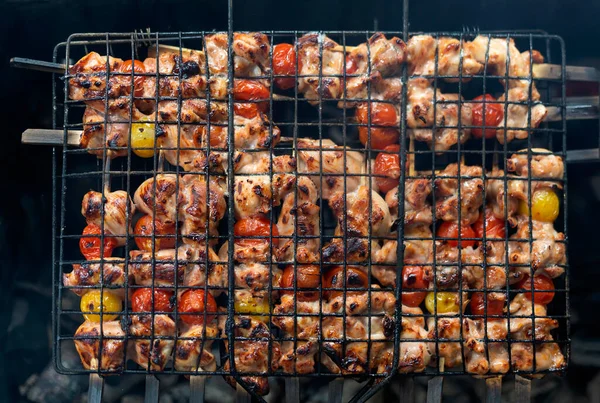Barbacoa con cocina de kebab, pollo frito con tomates cherry. —  Fotos de Stock