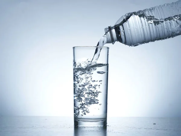 Image of pouring water from a water bottle into a glass