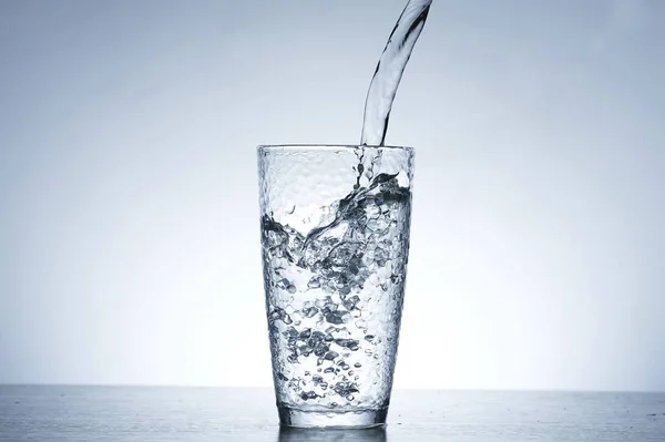 Foto Des Gießens Von Wasser Ein Glas Wasser — Stockfoto
