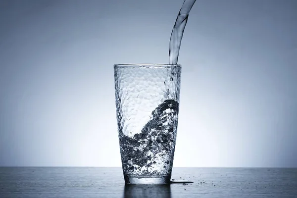 Foto Van Het Gieten Van Water Een Glas Water — Stockfoto