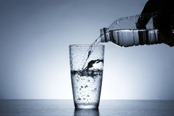 Photo of pouring water into a glass of water