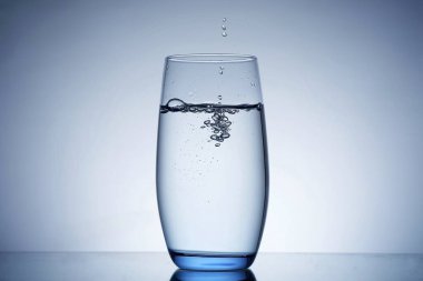 fotoğraf bardağa su döküyor.