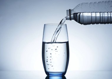 Su şişesinden bardağa su dökme görüntüsü