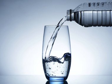 Su şişesinden bardağa su dökme görüntüsü