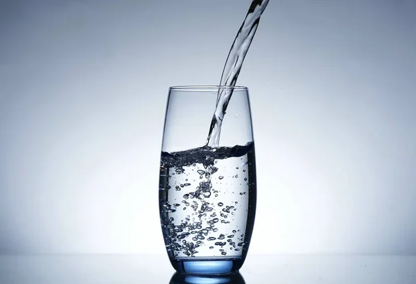 photo pouring water into a glass