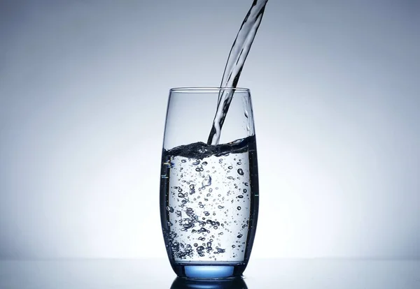 photo pouring water into a glass
