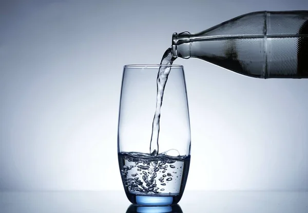 Image of pouring water from a water bottle into a glass