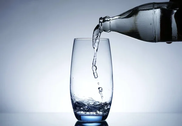 Image of pouring water from a water bottle into a glass