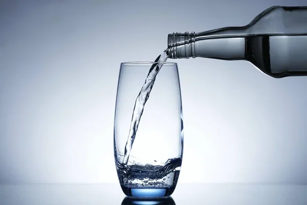 Image of pouring water from a water bottle into a glass