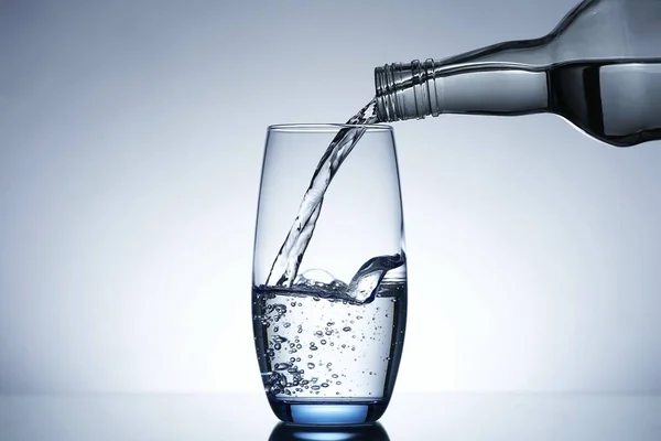 Image of pouring water from a water bottle into a glass