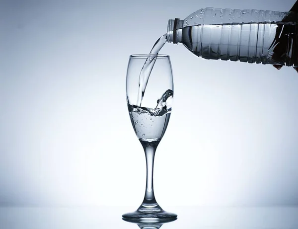 Image of pouring water from a water bottle into a glass