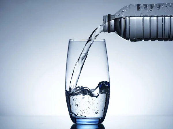 Image of pouring water from a water bottle into a glass