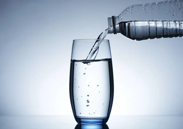 Image of pouring water from a water bottle into a glass