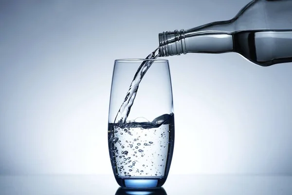 Image of pouring water from a water bottle into a glass