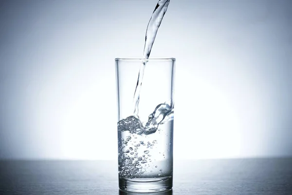 Photo of pouring water into a glass of water