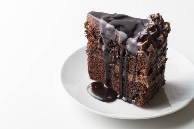 Çikolata damlayan soslu bir parça çikolatalı pasta. Beyaza izole edilmiş, fotokopi alanı ile.