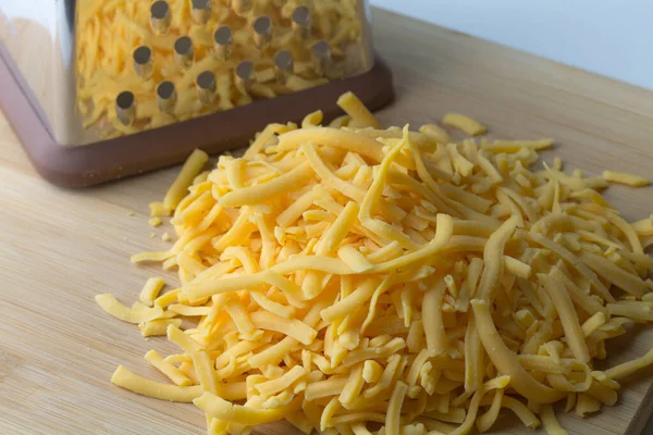 Geraspte Cheddar Kaas Een Hoop Met Kaas Shredder Achtergrond — Stockfoto