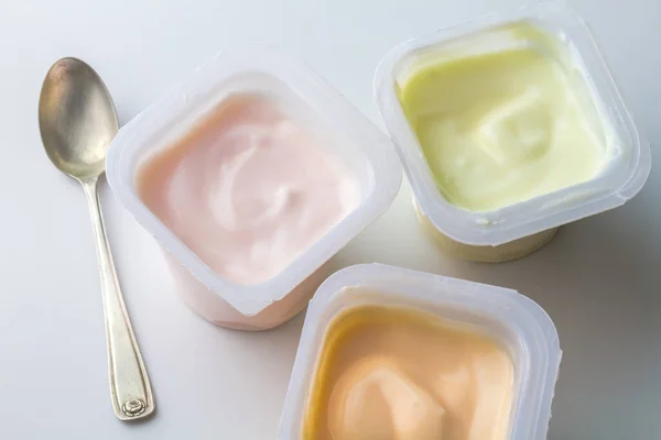 Gearomatiseerde Yoghurt Plastic Bekers Kleurrijke Fruit Gearomatiseerde Yoghurtbekers Geïsoleerd Wit — Stockfoto