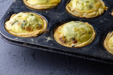 Mini quiche tarts in baking tray - small savoury pies