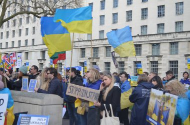 Londra 'daki insanlar Ukrayna' nın Rus işgalini protesto ediyorlar. Ukrayna bayraklarından feragat ediyorlar ve Ukrayna 'ya destek için bayrakları var..