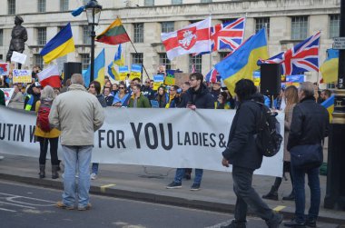 Londra 'daki insanlar Ukrayna' nın Rus işgalini protesto ediyorlar. Ukrayna bayraklarından feragat ediyorlar ve Ukrayna 'ya destek için bayrakları var..