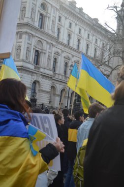 Londra 'daki insanlar Ukrayna' nın Rus işgalini protesto ediyorlar. Ukrayna bayraklarından feragat ediyorlar ve Ukrayna 'ya destek için bayrakları var..